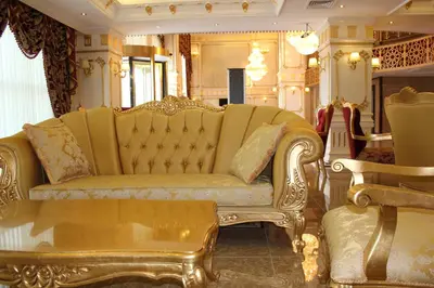a living room with a gold couch and a table at World Point Hotel Istanbul in Istanbul