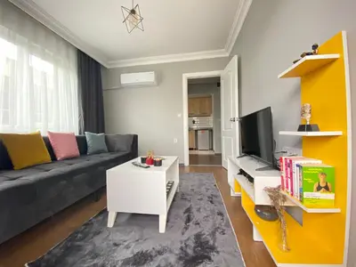 a living room with a couch and a tv at ANA GÜNEY Apart Otel in Nilüfer