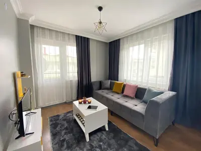 a living room with a couch and a table at ANA GÜNEY Apart Otel in Nilüfer