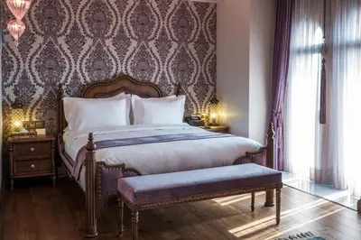 a bedroom with a large bed with a bench in it at AJWA Sultanahmet - Preferred Hotels LVX Collection in Istanbul