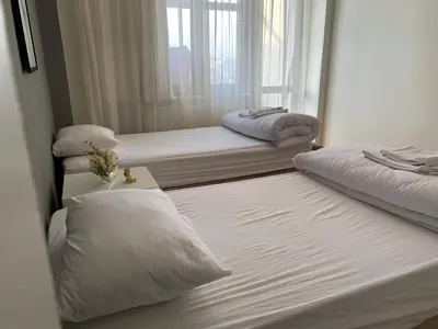 two beds in a room with a mirror at Kaplan Cosy Flat - All air conditioned & Heated 3 Bedrooms in the City in Istanbul