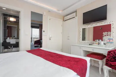 a bedroom with a white bed and a sink and a mirror at Dream Bosphorus Hotel in Istanbul