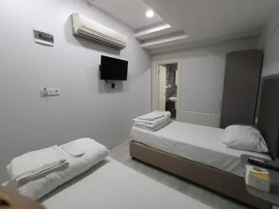 a bedroom with two beds and a tv on the wall at Emin Konak Hotel in Istanbul