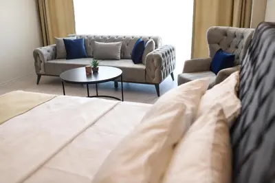 a living room with a couch and two couches and a table at PETRA HOTEL TUZLA in Tuzla