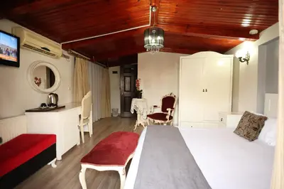 a bedroom with a white bed and a red couch at Asmali Hotel in Istanbul