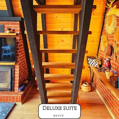 a wooden staircase in a room with a fireplace at VADİ BUNGALOV SAPANCA in Sapanca