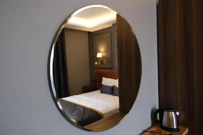 a mirror reflecting a bedroom with a bed in a room at The Pearl Airport Hotel in Arnavutköy