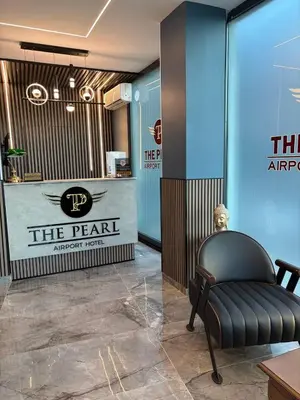 a waiting room with a chair in front of a sign at The Pearl Airport Hotel in Arnavutköy