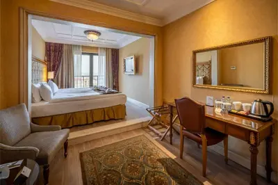 a hotel room with a bed and a desk and a mirror at The Central Palace Taksim in Istanbul