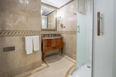 a bathroom with a shower and a sink and a mirror at The Central Palace Taksim in Istanbul