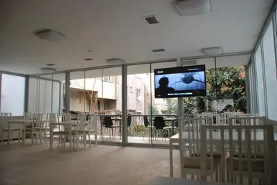 a room with tables and chairs and a flat screen tv at Bursa Park Apart Hotel in Bursa