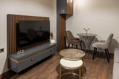 a living room with a tv and a table and chairs at Nm Suites Beyoglu in Istanbul