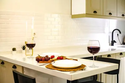 two glasses of wine and a plate of food on a kitchen counter at Cihangir VAV Suites in Istanbul