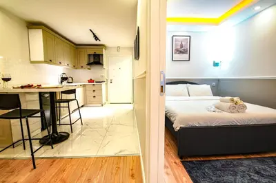 a small room with a bed and a kitchen at Cihangir VAV Suites in Istanbul