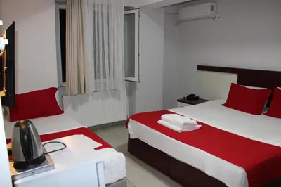 a hotel room with two beds with red pillows at Deniz Hotel Kumburgaz in Buyukcekmece