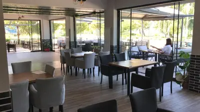 a woman sitting at a restaurant with tables and chairs at ANTİGONİA BUTİK OTEL in İznik