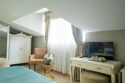 a bedroom with a bed and a desk and a chair at Valide Hotel in Istanbul