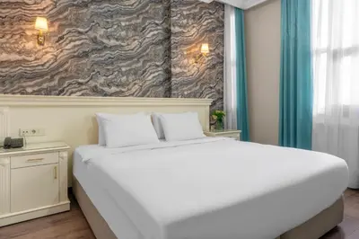 a large white bed in a room with a wall at Valide Hotel in Istanbul