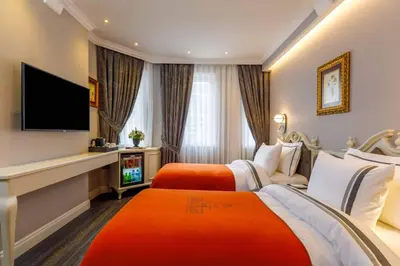 a hotel room with two beds and a television at Amiral Palace Hotel Boutique Class in Istanbul