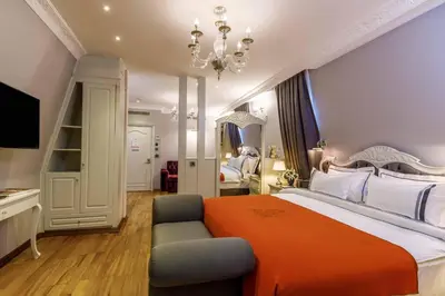 a bedroom with a large bed with an orange blanket at Amiral Palace Hotel Boutique Class in Istanbul