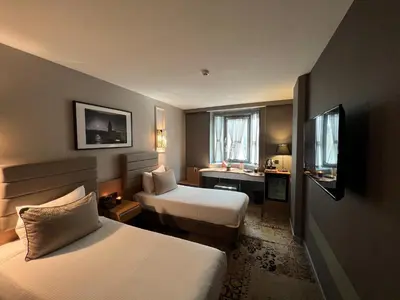 a hotel room with two beds and a desk at All Seasons Hotel in Istanbul
