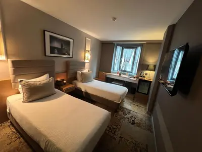 a hotel room with two beds and a desk at All Seasons Hotel in Istanbul