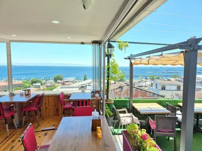 a balcony with tables and chairs and a view of the ocean at VERSECA HOTEL in Istanbul