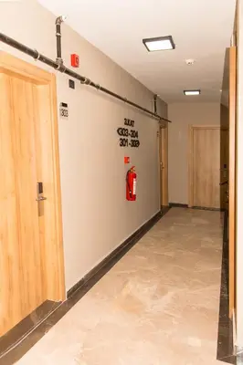 a hallway with a fire extinguisher on the wall at Fidanoğlu Suite Hotel Çorlu in Corlu