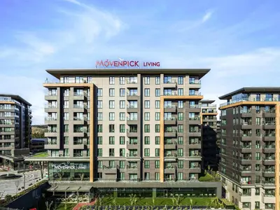 a large building with a sign on top of it at Movenpick Living Istanbul Camlivadi in Istanbul
