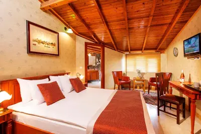 a bedroom with a large bed with a desk and chairs at Hotel Erguvan - Special Category in Istanbul