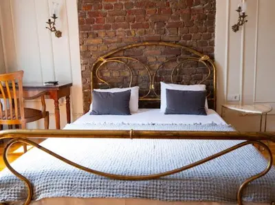 a bed in a room with a brick wall at Fatih Balat tarihin içinde şık bir ev 2 in Istanbul