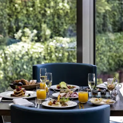 a table with plates of food and glasses of orange juice at Conrad Istanbul Bosphorus in Istanbul