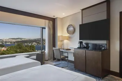a hotel room with a bed and a desk and a television at Conrad Istanbul Bosphorus in Istanbul