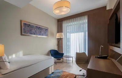 a hotel room with a bed and a chair and a desk at The Superior Living Batışehir in Istanbul