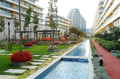 a river in a city with flowers and buildings at The Superior Living Batışehir in Istanbul