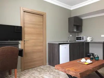 a kitchen with a wooden door and a table at Grand Park Hotel Corlu City Center Bed and Breakfast in Corlu