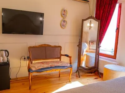 a living room with a chair and a mirror at Fatih Balat Tarihten nezih şık ev- 1 in Istanbul