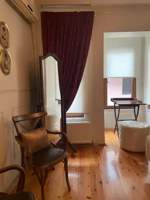 a living room with a chair and a mirror at Fatih Balat Tarihten nezih şık ev- 1 in Istanbul