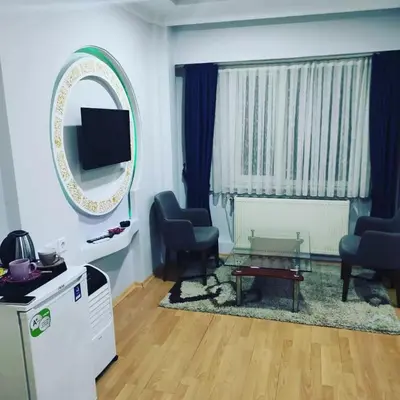 a living room with two chairs and a table and a mirror at CEMRE SUIT in Istanbul
