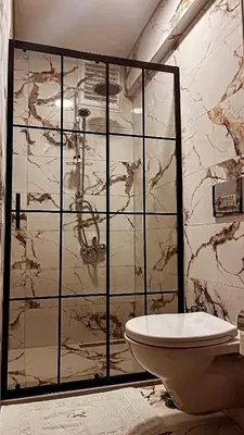 a bathroom with a glass shower and a toilet at CEMRE SUIT in Istanbul
