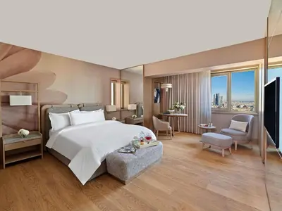 a bedroom with a large white bed and a desk at Mövenpick Hotel Istanbul Bosphorus in Istanbul