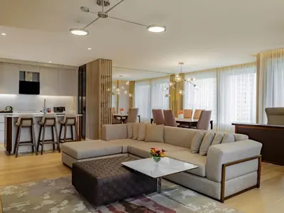 a living room with a couch and a table and a kitchen at Mövenpick Hotel Istanbul Bosphorus in Istanbul