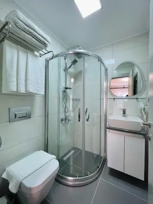 a bathroom with a shower and a toilet and a sink at Apex Hotel in Istanbul