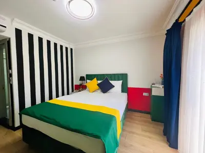a bedroom with a bed with colorful sheets and pillows at Apex Hotel in Istanbul