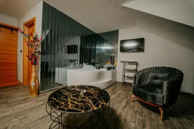 a living room with a chair and a bath tub at Grand Quars Hotel in Avcılar