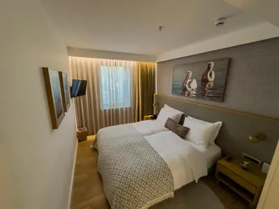 a bedroom with a large bed with white sheets at Pınar Otel in Erdek