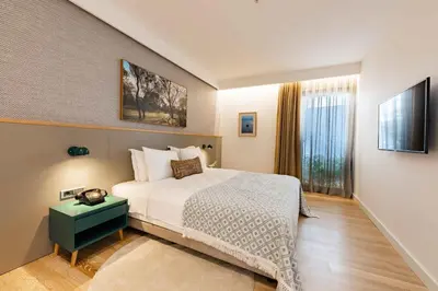 a bedroom with a bed and a television in it at Pınar Otel in Erdek