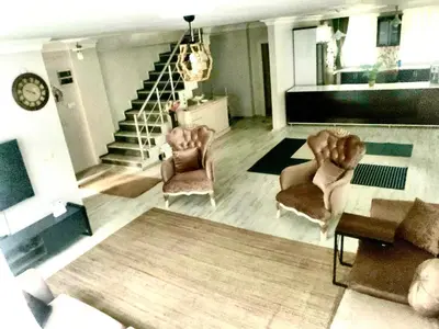 a living room with two chairs and a staircase at Ahmet Teacher's villa is 6 minutes from Istanbul airport in Arnavutköy