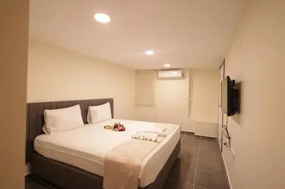 a bedroom with a bed with white sheets and a television at Bonita Apart in Istanbul