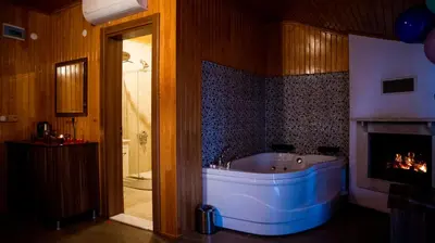 a bathroom with a tub and a fireplace at DEFNE OTEL in Sile